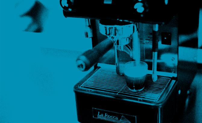 Foto de color azul con detalle de vaso de café con café encima de la máquina de café Alin