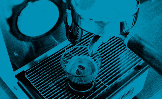 Foto de color azul con detalle de vaso de café con café encima de la máquina de café Retro